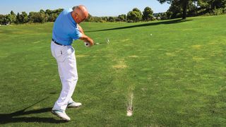 Keith Williams strikes the golf ball from a divot