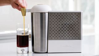 Person using AstroBrew coffee maker to dispense cold brewed coffee