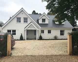 large gravel driveway in front of a modern house with porch