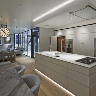 Modern white open plan kitchen with hidden lighting