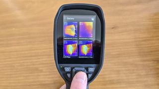 A person holding a thermal imaging camera