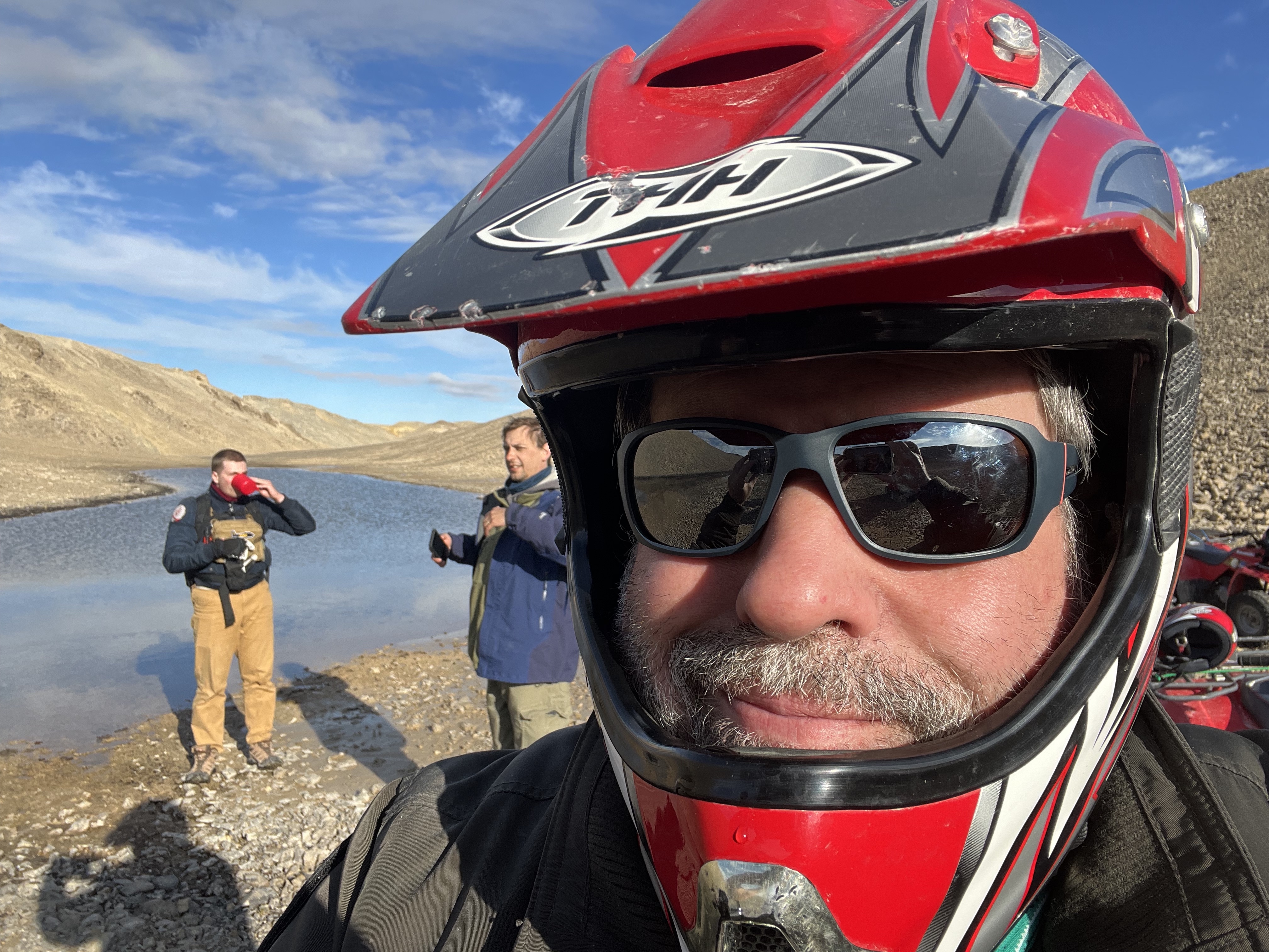 A man in a motorcycle helmet takes a selfie in the Arctic