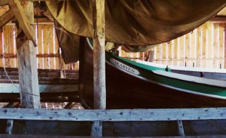 A traditional fishing boat, relating to the old Viking longships, is stored in the boathouse at the Old Trading Post on Kjerringøy, a short boat ride from Sandhornøya