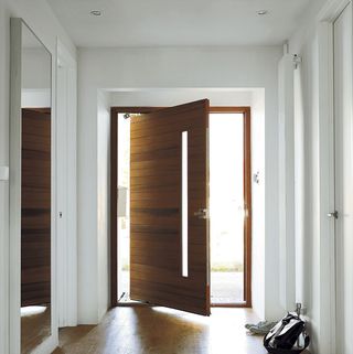 Entrance door with white wall and wooden flooring
