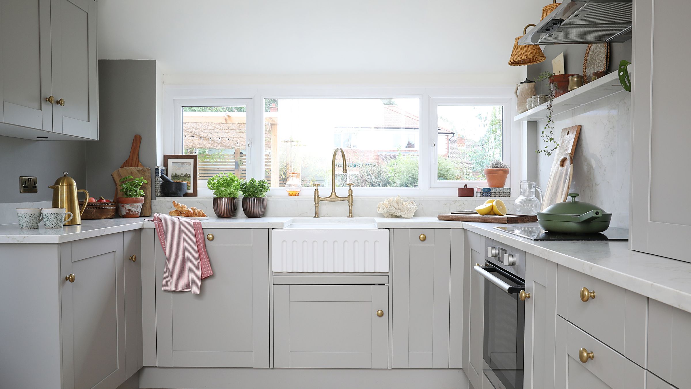 Small grey kitchen with white countertops and a white sink