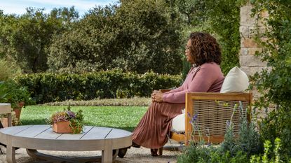oprah winfrey seated on walmart outdoor chair in garden with outdoor coffee table