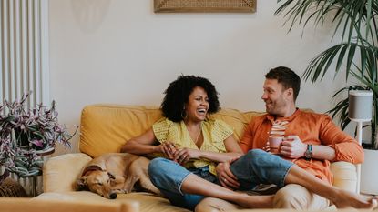 Happy young couple on the couch with their dog