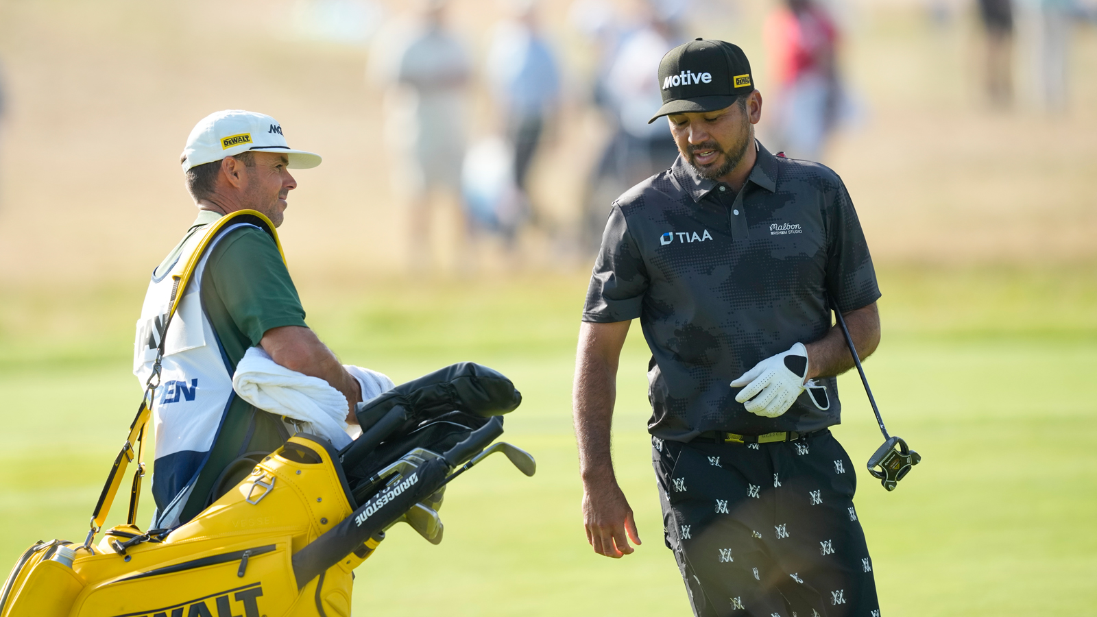 Jason Day and his caddie react to a putt on the green at the US Open