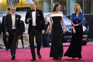 Prince William, Duke of Cambridge and Catherine, Duchess of Cambridge (C) arrive with Cameron Saunders (L) and Alex Pumfrey (R) of the Film and TV Charity for the "Top Gun: Maverick" Royal Film Performance