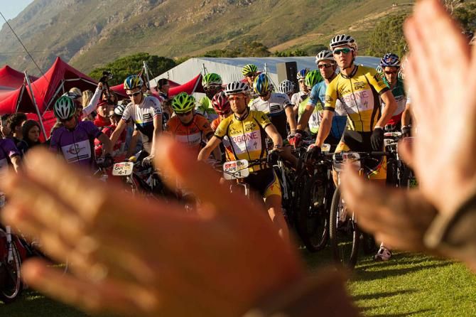 Crowds cheer on the lead riders as they prepare to set off for the final stage