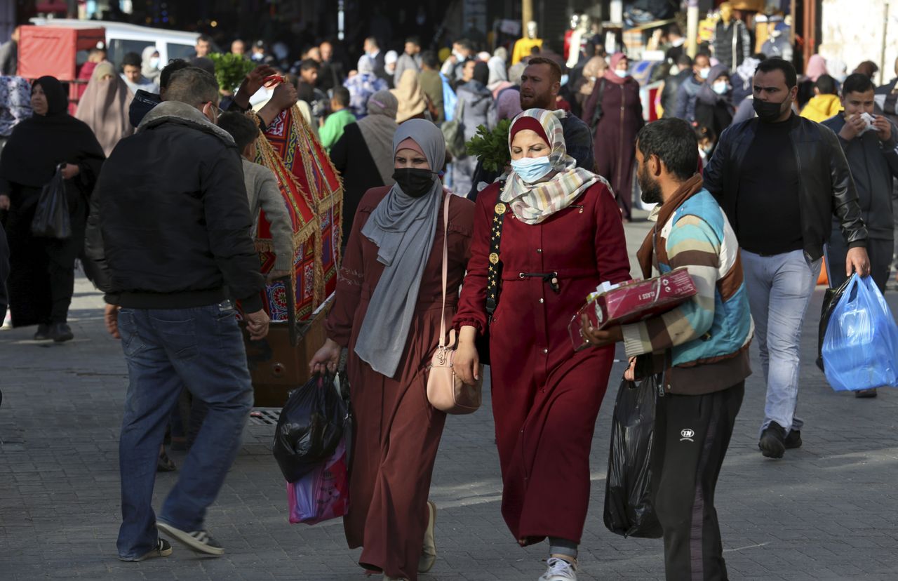 People walk through the main market in Gaza City on Sunday.