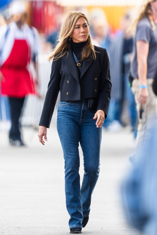 Jennifer Aniston wears a cropped blazer and jeans