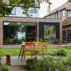 Adding more space the exterior rear of a house with garden and a wraparound extension and sliding doors