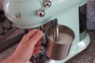 Smeg espresso machine being used to steam milk