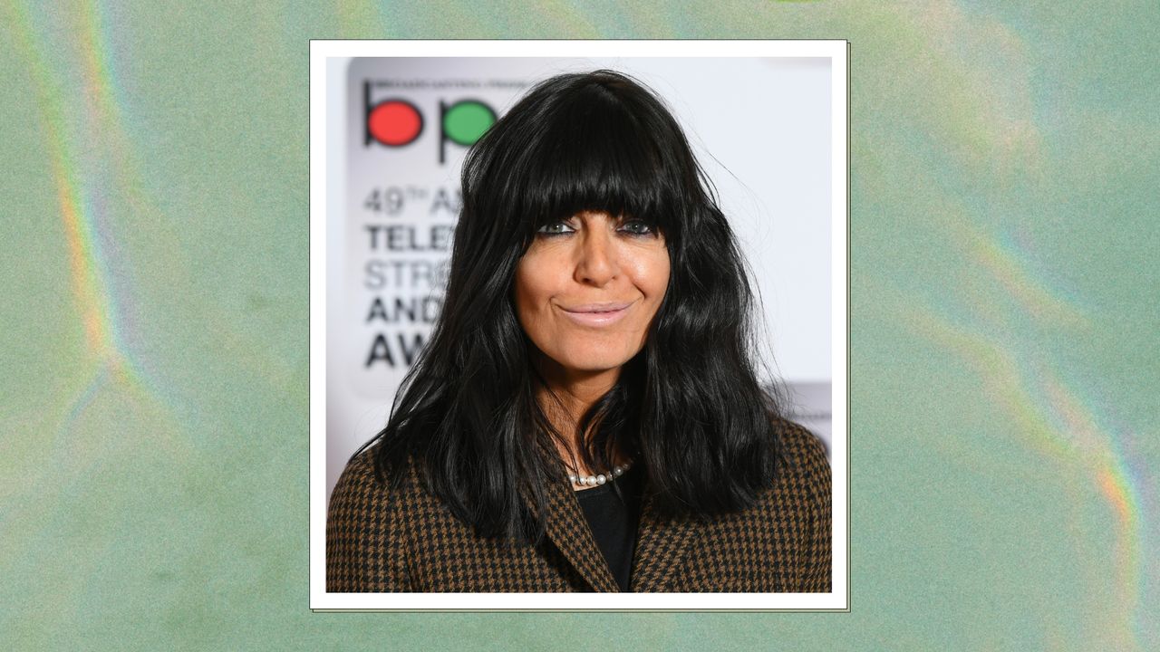 Claudia Winkleman with black wavy bob and block fringe, with a green marbled background