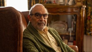 A bespectacled Sir David Suchet as George sits in a chair in The Au Pair.