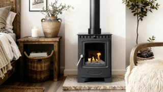 black bioethanol stove on marble hearth in bedroom with wooden floor