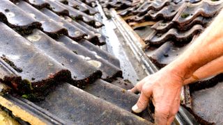 Close up of hands replacing a clay roof tile