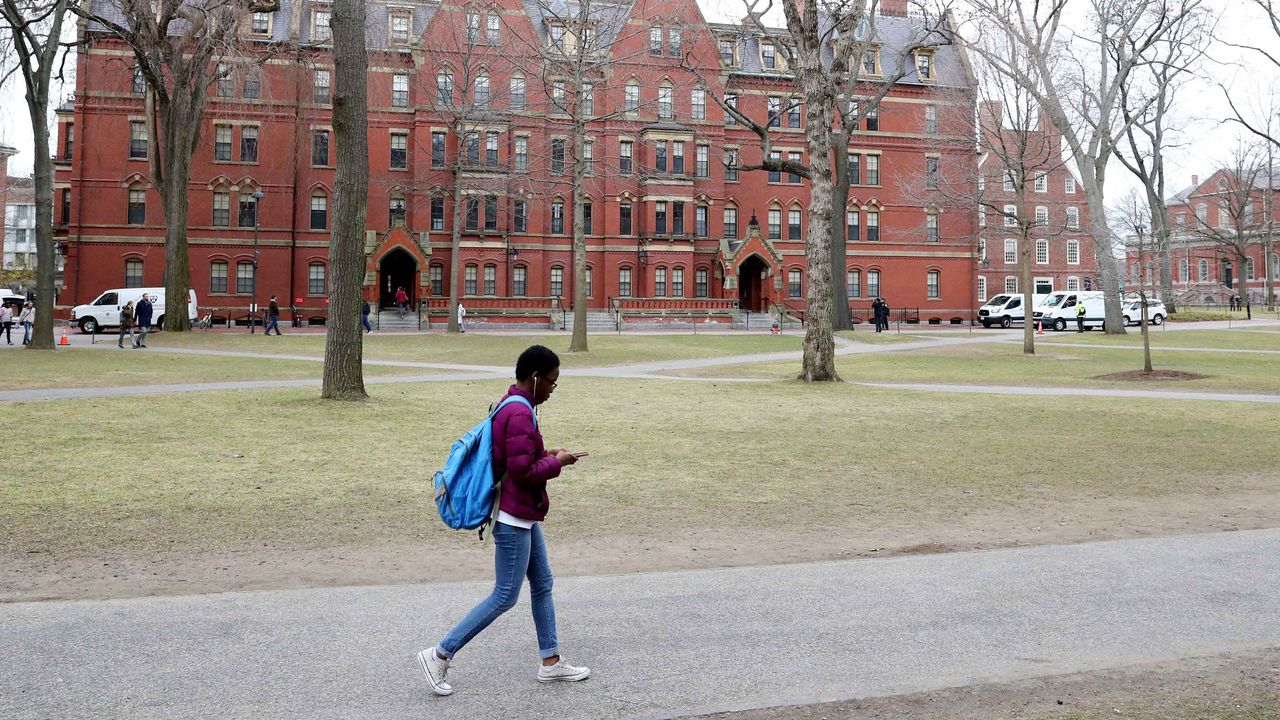 A lone college student walks an otherwise empty college street