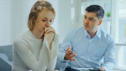 A financial adviser consoles a client as she gets emotional about financial issues.