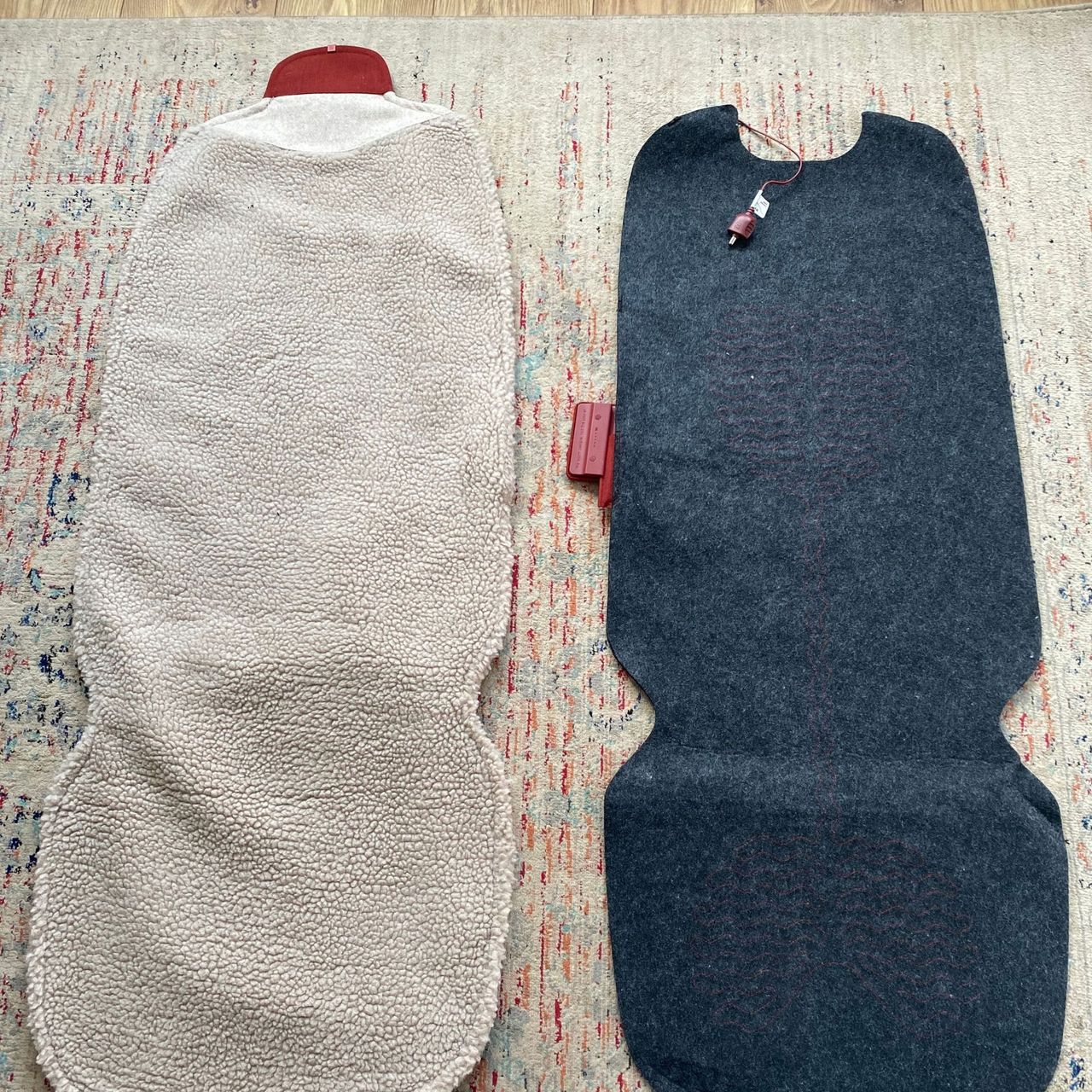 The Stoov Big Hug3 woolly cover lying next to the heating element mat from inside on a patterned rug