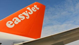 The EasyJet logo on the rudder of a large aircraft.