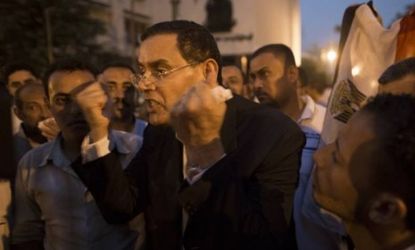 Egyptian MP Mohammed Aouf speaks to the media outside the parliament on June 19, as riot police blocked the entrance to the building to prevent members of the recently-scrapped legislature fr