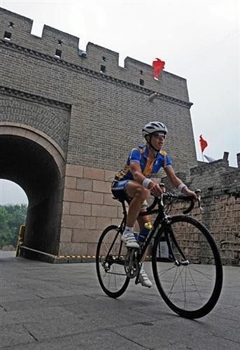 Susanne Ljungskog, of Sweden's cycling team, passes under an arc