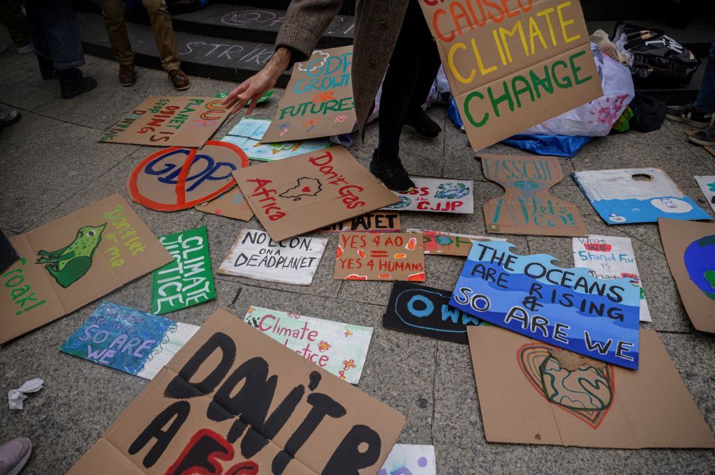 An activist picks up a placard at climate group Fridays for Future&#039;s march during a Global Climate Strike in New York on March 3, 2023