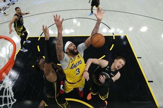 Anthony Davis of the Los Angeles Lakers for a ball against Kevon Looney and Donte DiVincenzo of the Golden State Warriors in game one of the Western Conference Semifinal Playoffs at Chase Center on May 02, 2023.
