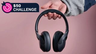 Tribit QuietPlus 81 held in a man's hand on pink background, with TechRadar's '$50 challenge' badge in the top-left corner