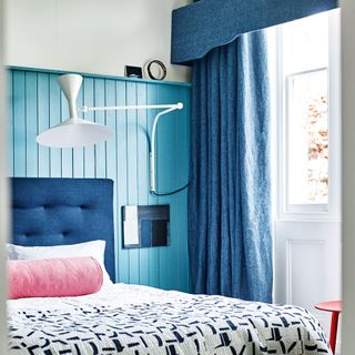 Bedroom with blue panelled wall behind bed