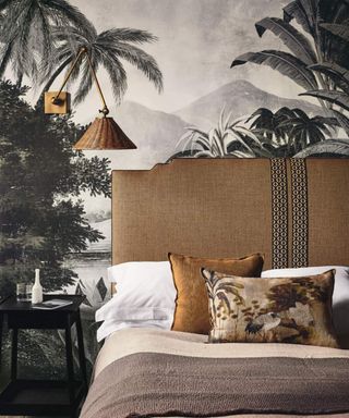 Bed with a brown headboard against a safari themed wallpaper