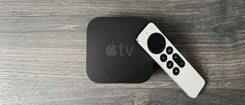 Apple TV 4K (2021) with white remote against wooden surface