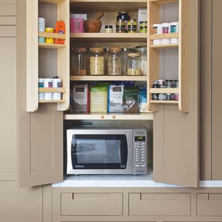 cupboard with microwave and glass jars