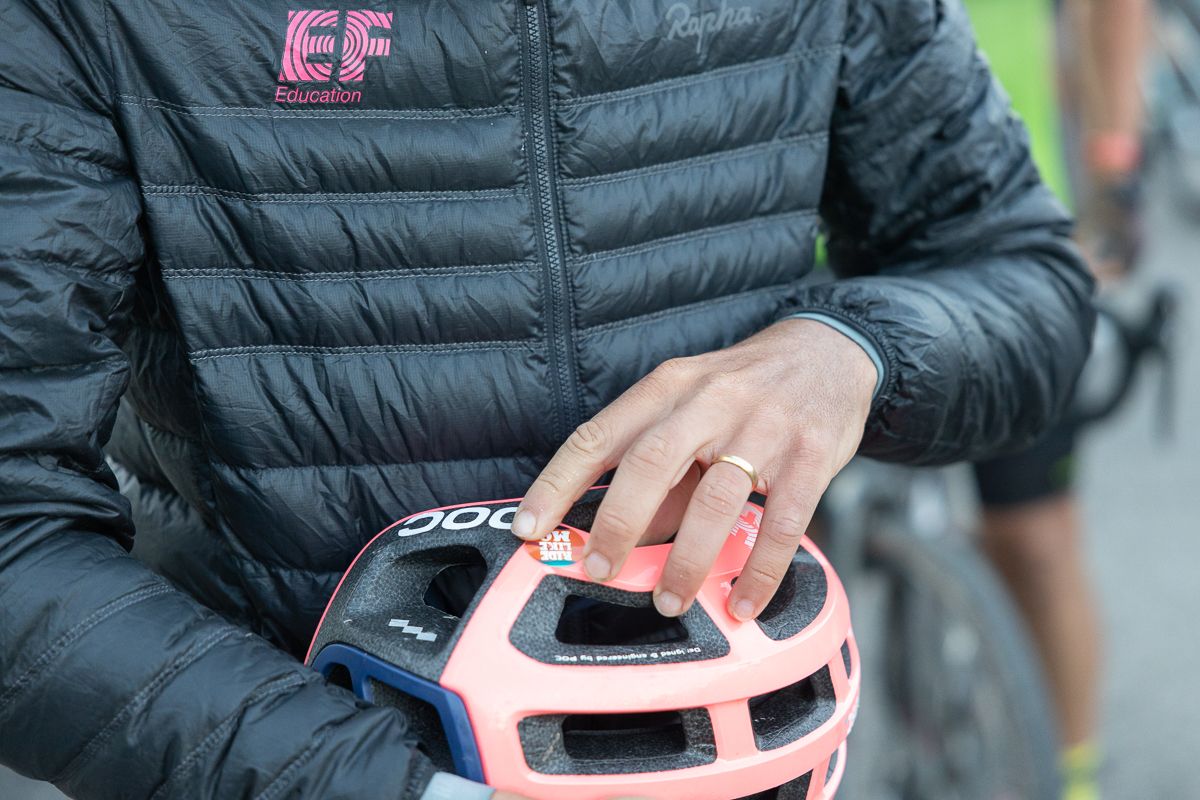 Lachlan Morton (EF Education) applies a "Ride like Mo" sticker to his helmet.