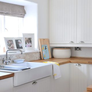 kitchen area with wooden worktop and sink with cabinet