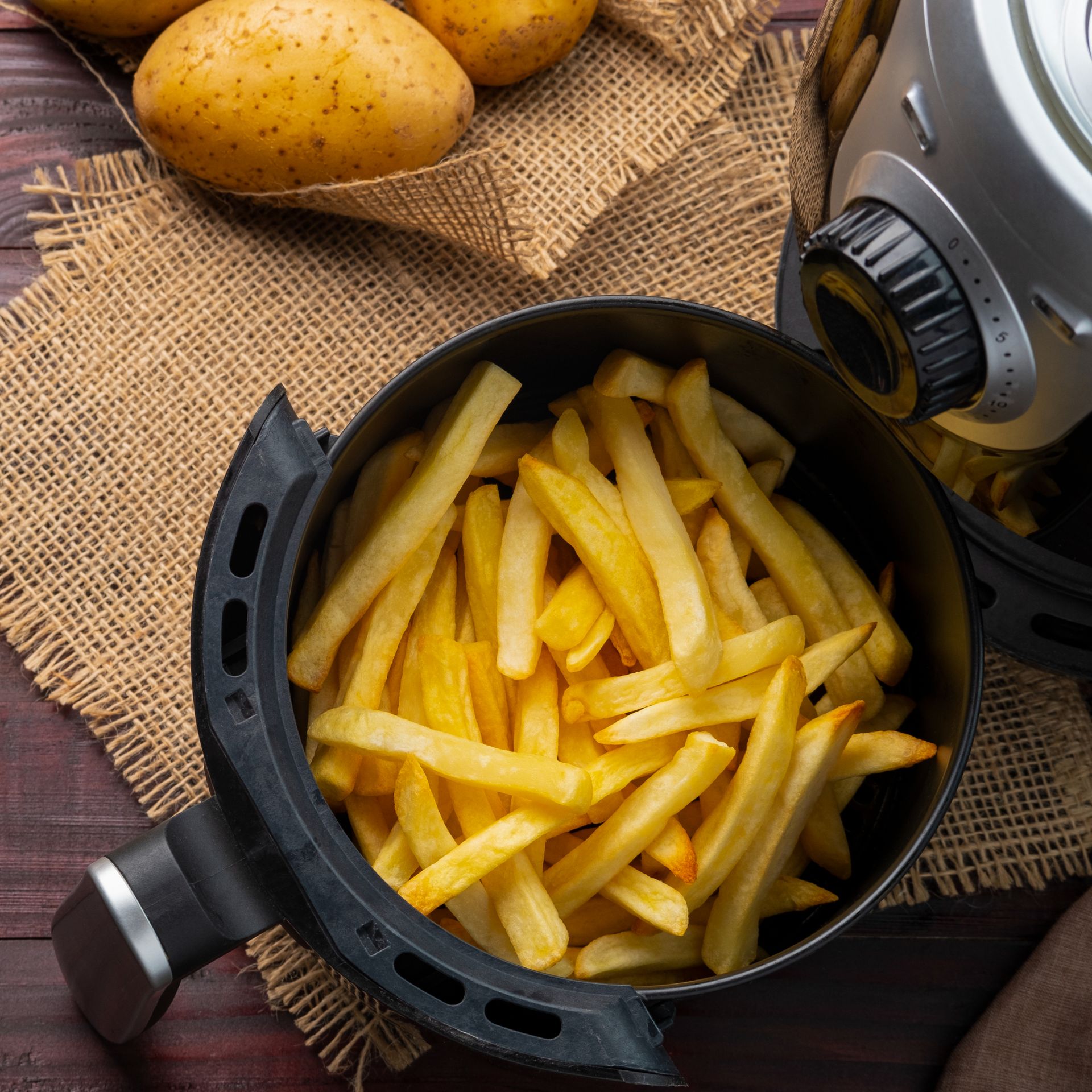 Air fryer cooking chips on kitchen worktop