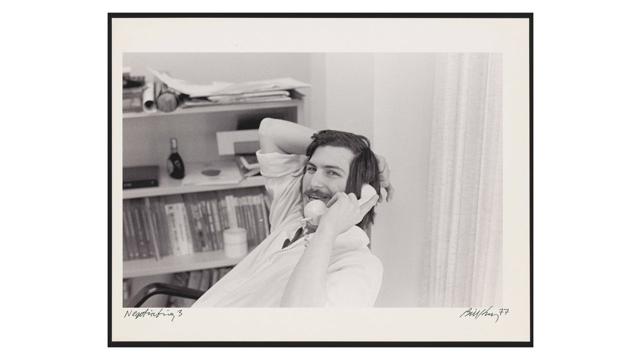 Steve Jobs on the phone (photo by Bill Kelley). Caption in book reads: Apple outgrew its headquarters twice in 1977