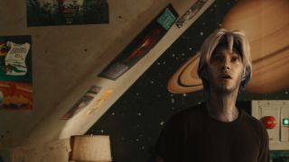 Parzival in Halliday's room in Ready Player One with posters on the wall.