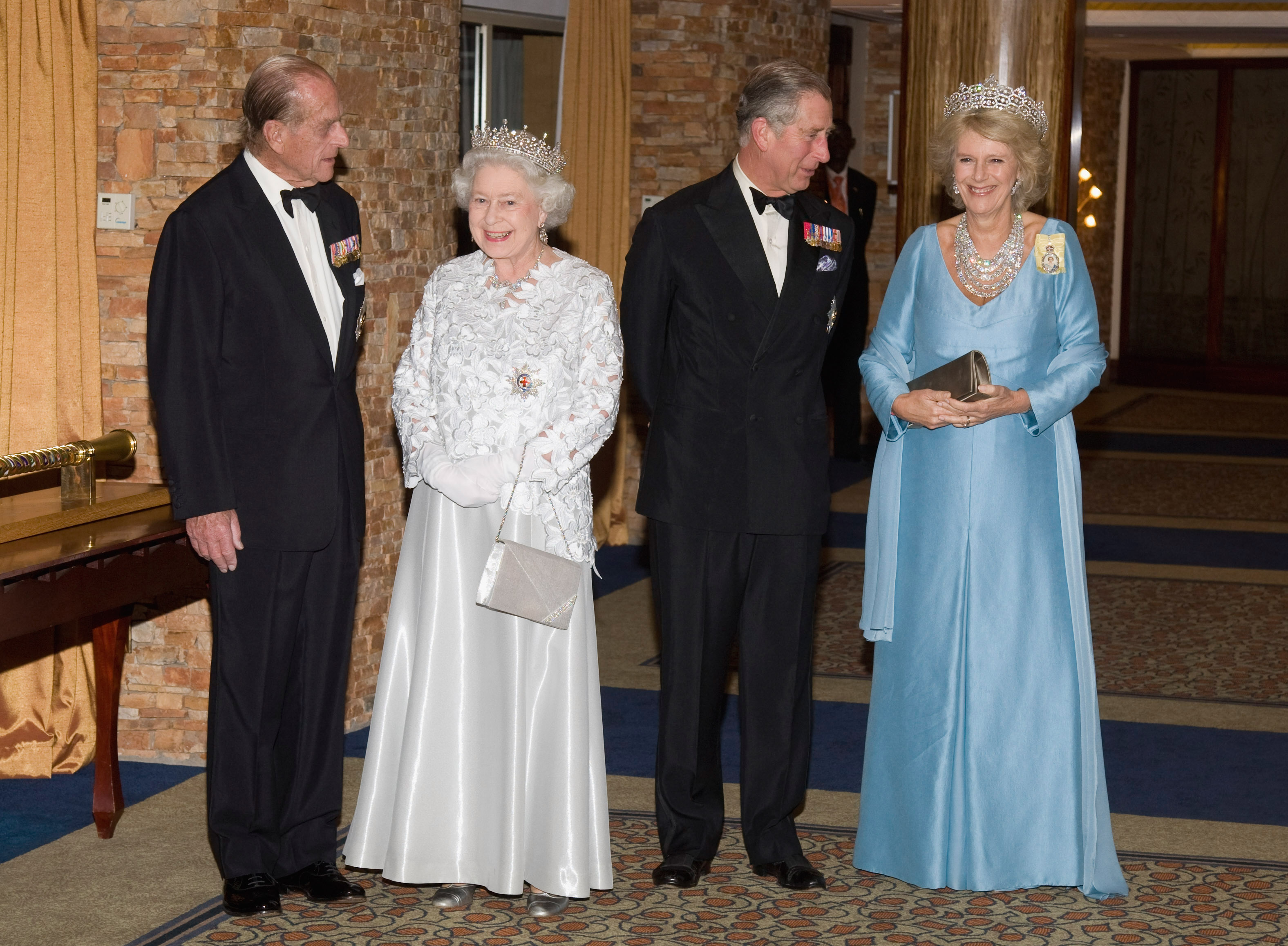 Prince Philip, Queen Elizabeth, King Charles and Queen Camilla wearing evening gowns and tuxes