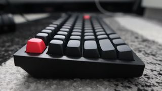 The Keychron Q3 Max gaming keyboard set-up on a desk with the RGB lighting enabled.