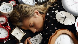 Sleeping woman surrounded by clocks