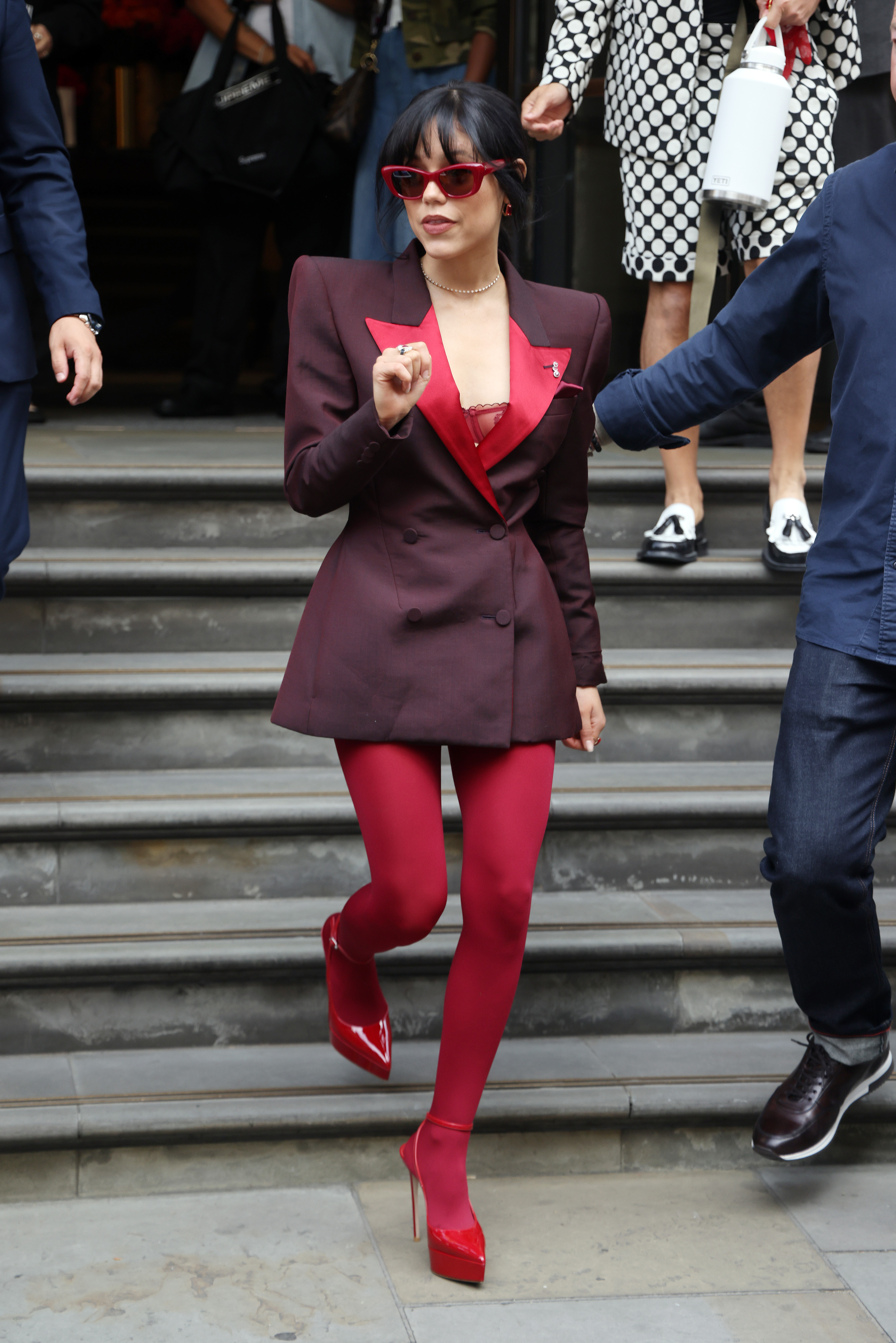 Jenna Ortega was spotted in London wearing a burgundy Alexander McQueen blazer as a dress