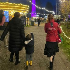 Princess Eugenie, August Brooksbank, Sarah Ferguson and Ernest Brooksbank with their backs facing the camera walking along a lit up dirt path at night