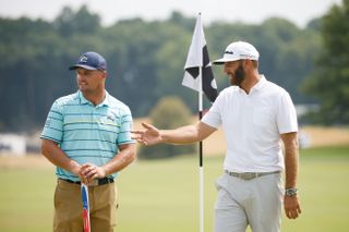 Johnson and DeChambeau chat next to a flag