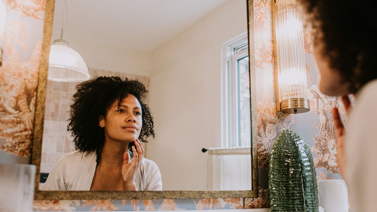 woman looking in the mirror at her milia