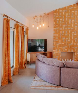 Yellow living room scheme with yellow velvet curtains and yellow geo wallpaper on fireplace feature wall