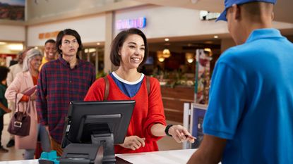 a woman using her credit card to pay for movie tickets