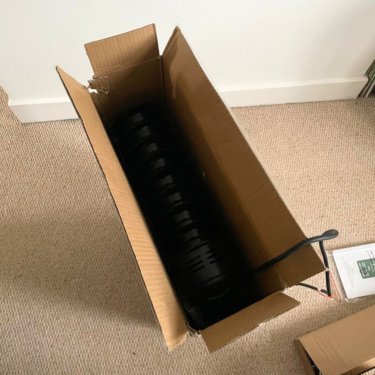 Opening the box of the Dunelm oil-filled radiator, with the black radiator poking out the top